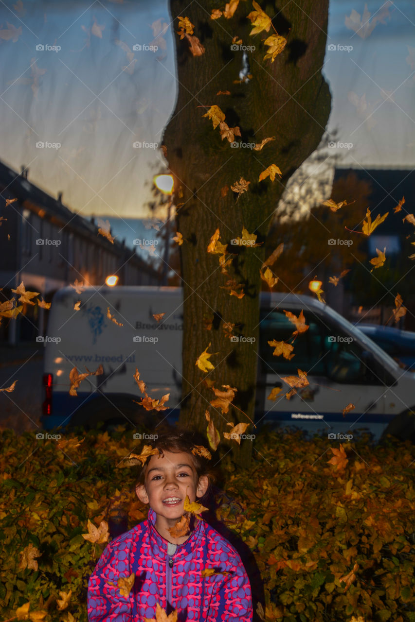 Little girl throwing leafs up in the air