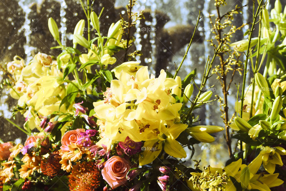 Beautiful and colorful floral arrangement with a fountain in the background