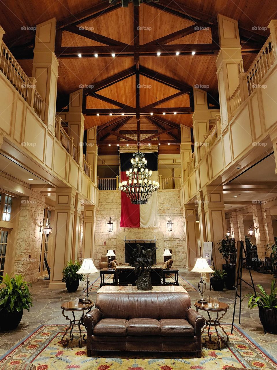 A grand resort entrance in Texas proudly features a large Texas state flag along with rich leather seating and warm lighting in a beautiful interior space