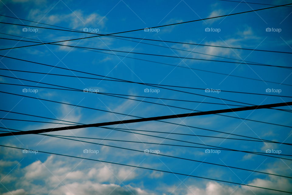 Crossed power lines on a blue sky