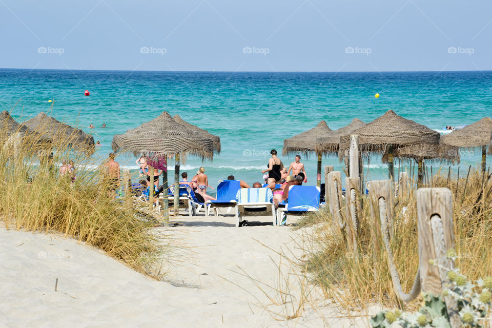 Tourists enjoying the beach at Alcudia Pins Majorca Spain.