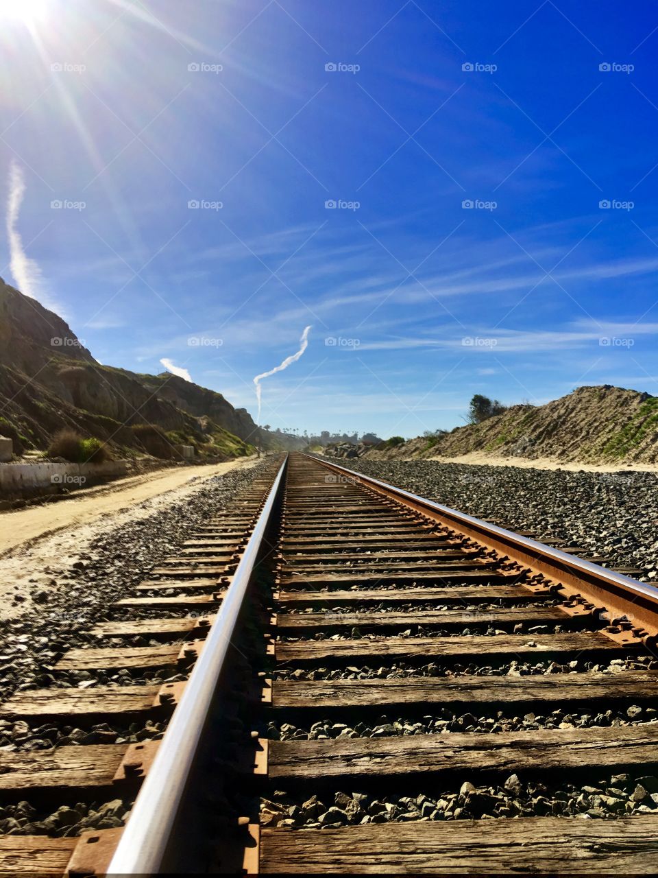 Foap Mission Perspective Matters! Railroad Tracks From A Low Perspective With Blue Sky’s, Clouds And Hillsides !