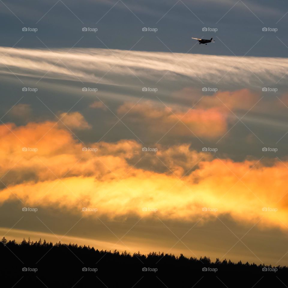 Plane taking off at sunset