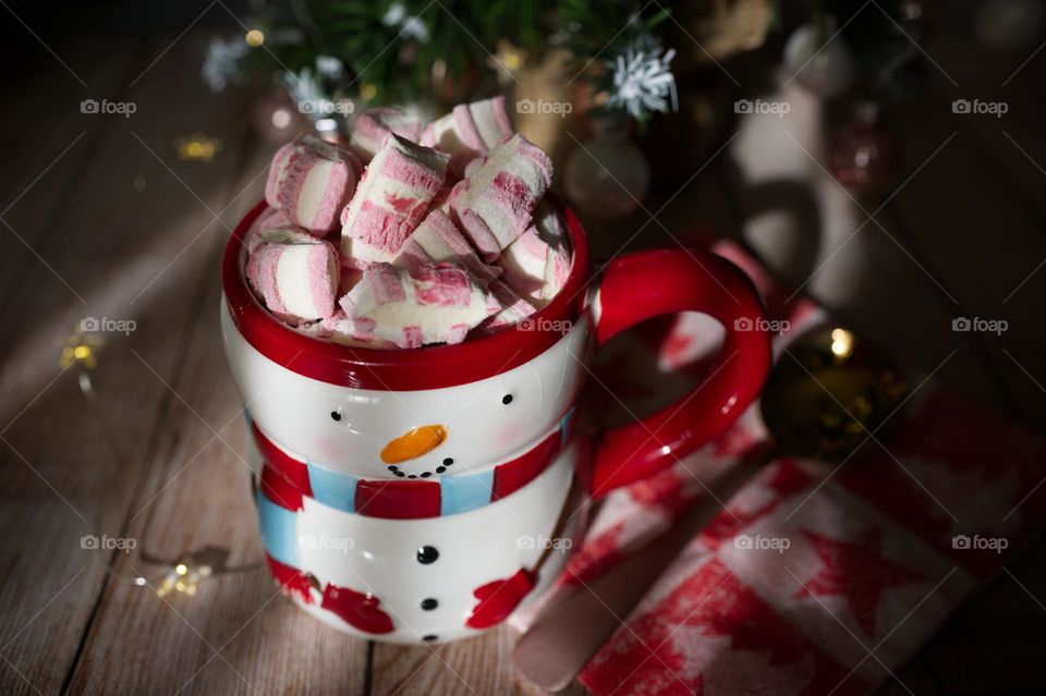 a cup of chocolate in the shape of a snowman with marshmallows