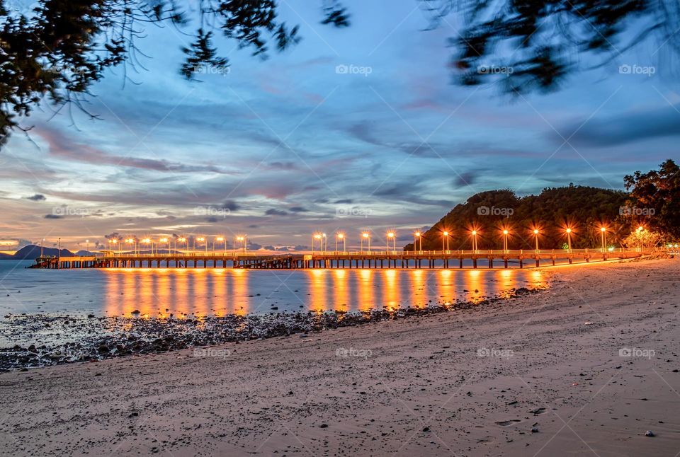 Beautiful lighting and reflection of lamp light on the sea in twilight moment