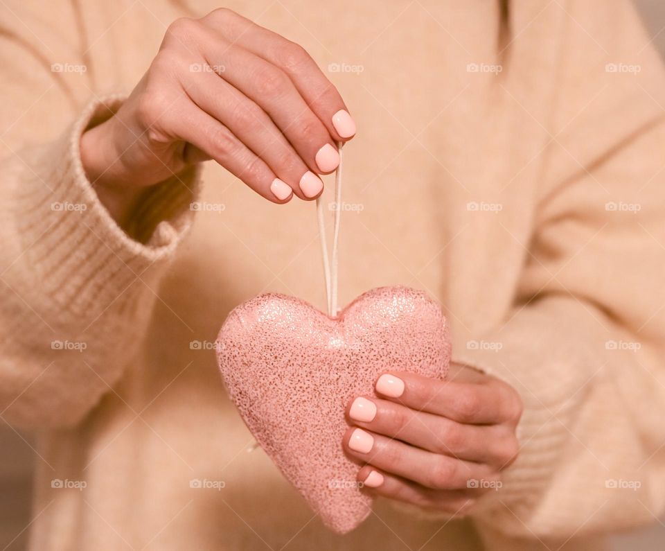 human hands holding heart shape decor