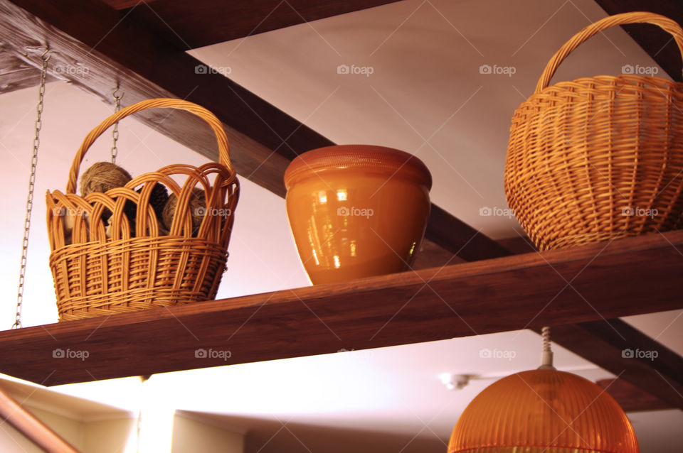 clay pots and vessels stand on a shelf in a rustic kitchen