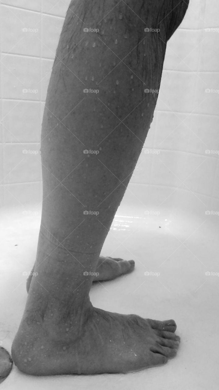 Man's feet and legs in the shower