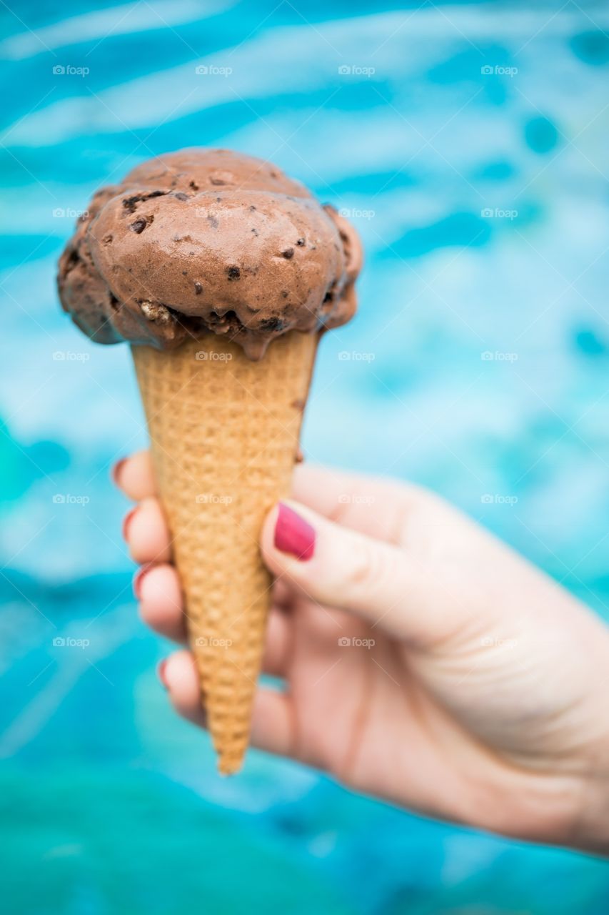 Human hand holding a chocolate ice cream