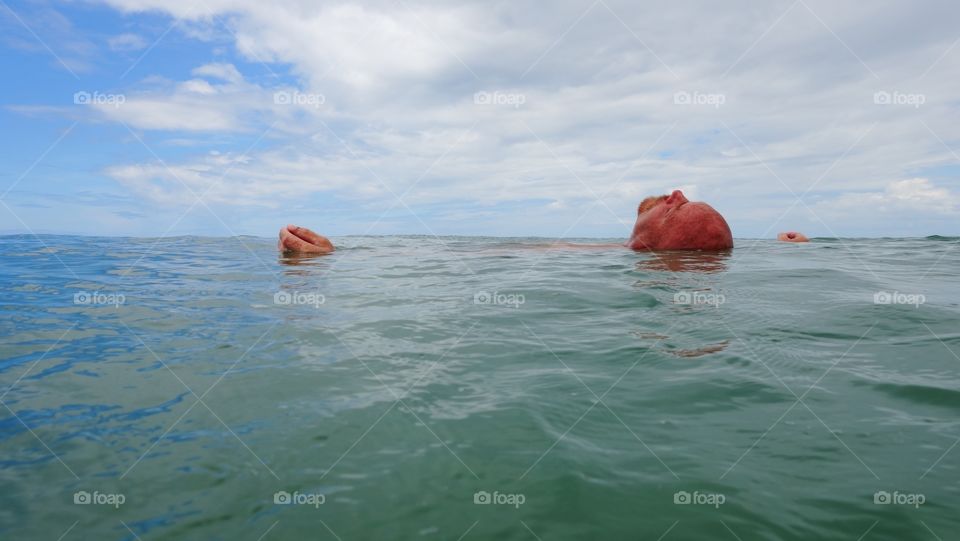 Mature bald man swimming in the sea