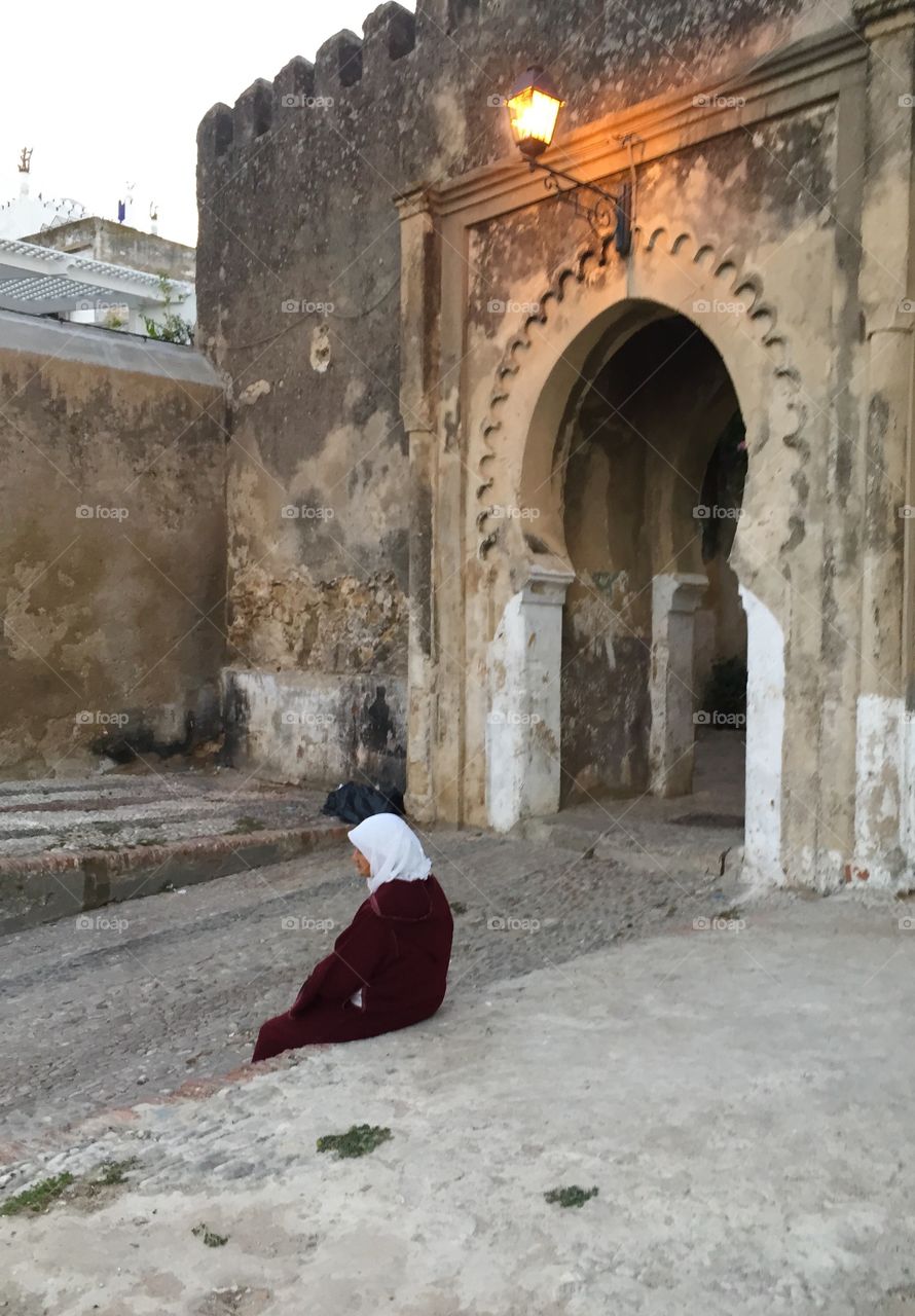 Lady sitting near an arch. In the medina in Tangier