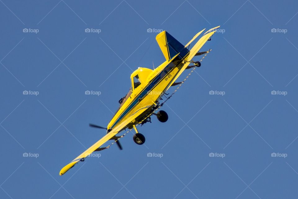A crop duster completes its work over the fields of Victoria