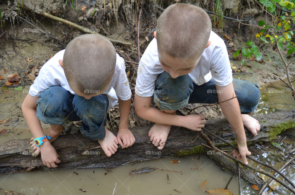 Brothers looking in a creek