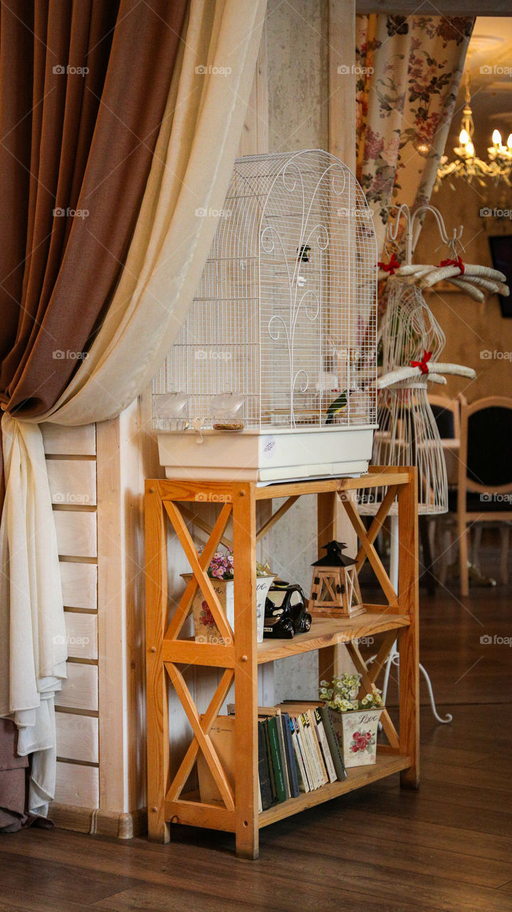 cozy interior with books and a cage