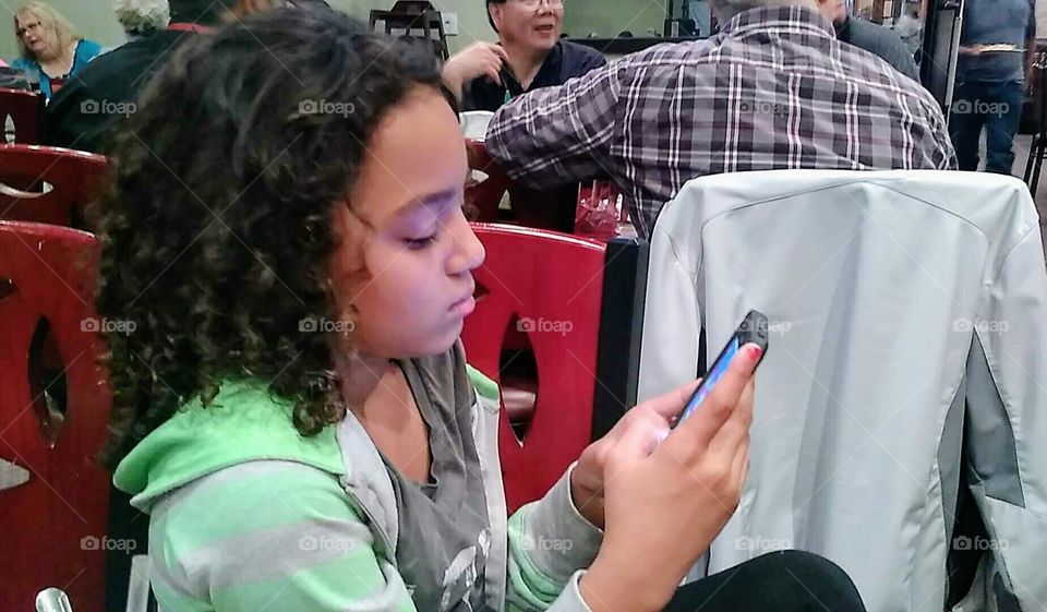 Girl playing app on phone.