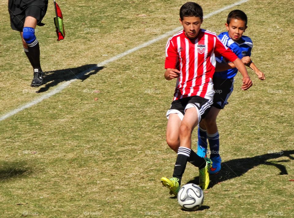 Youth Soccer. Boys Playing Soccer On A Sunny Field
