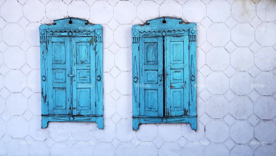 old vintage blue wooden shutters for windows.  white concrete wall.