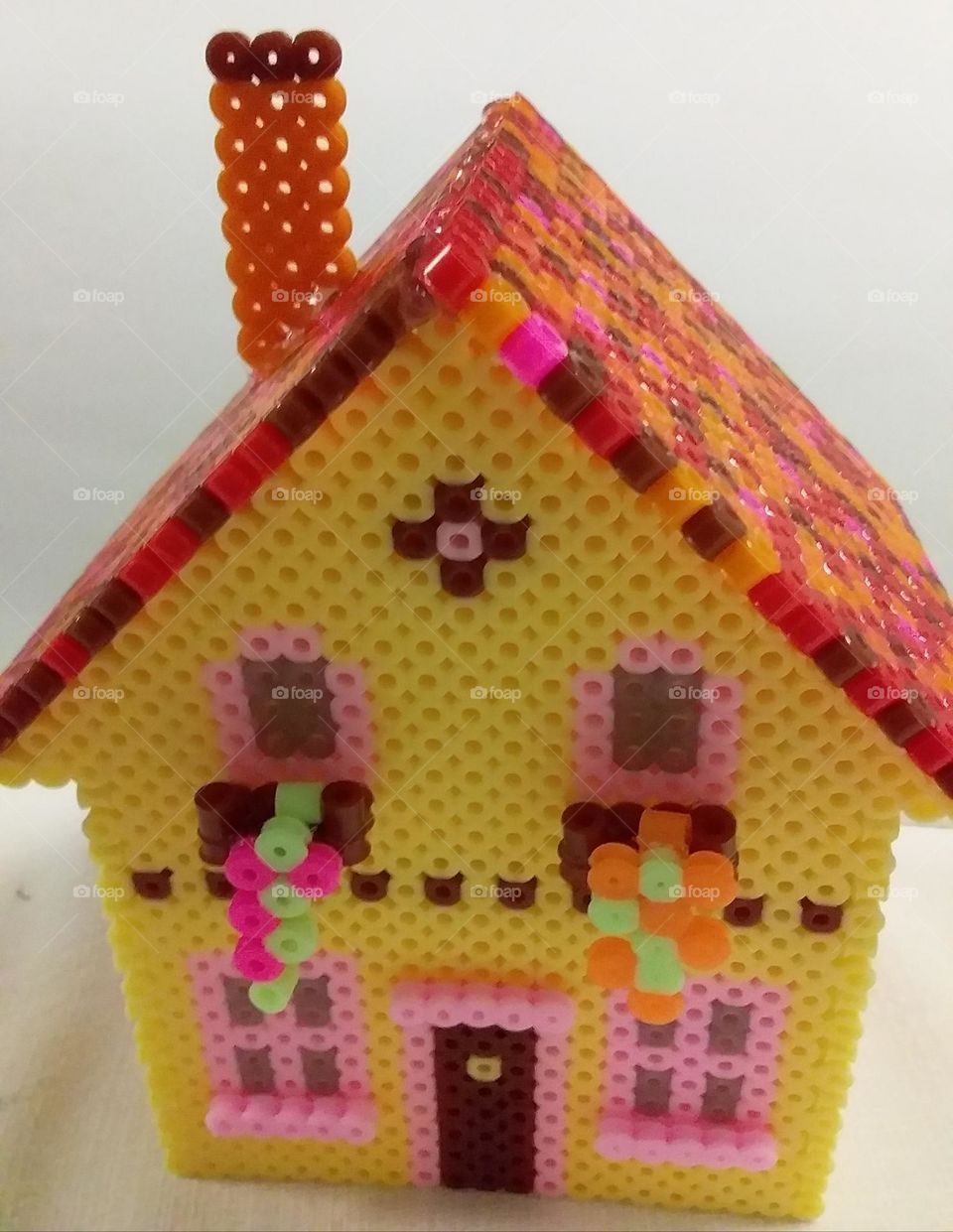 a brightly coloured house made from pearler beads