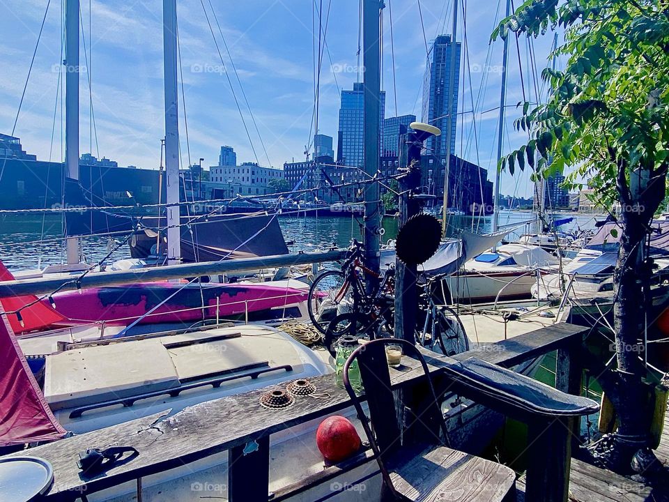 This is a view of the boat directly opposite us carrying the three bicycles with it. Across the water of the “East River” here at “Newtown Creek” by the “Pulaski Bridge” in LIC, Queens we see “Greenpoint”, Brooklyn. 2023. Hypnotic Productions