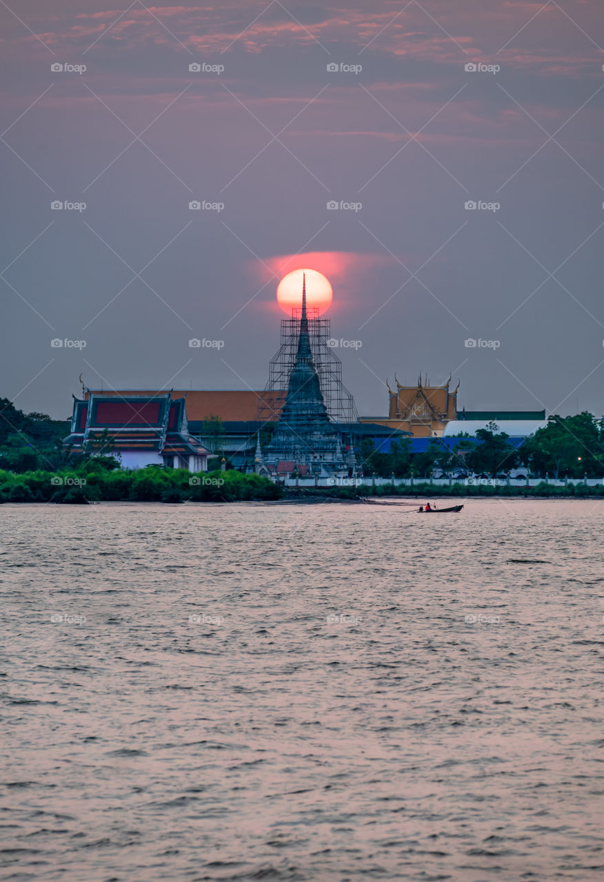 Sailing come back to home in the sunset above Thai pagoda