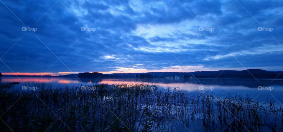 White nights and midnight sun on a lake in Finland at midsummer eve.