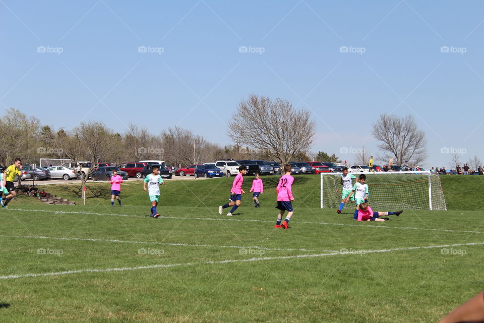 Kids playing soccer in a beautiful spring day 