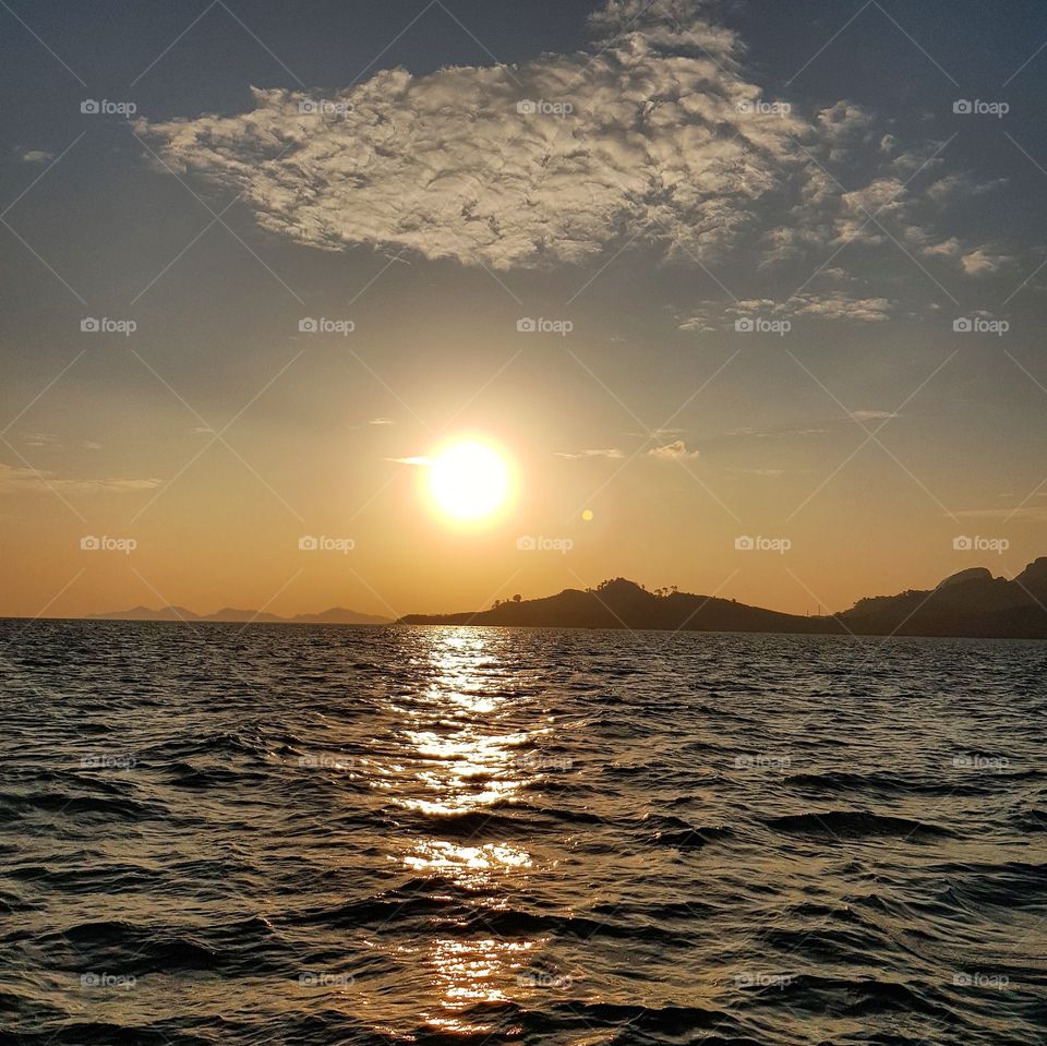 Scenic view of sea against sunlight