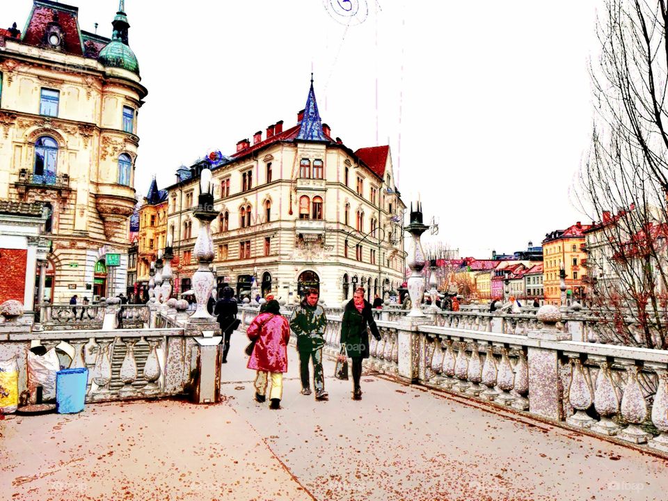 Passers-by on Triple Bridge in quaint historic oldtown of Ljubljana, Slovenia's capital