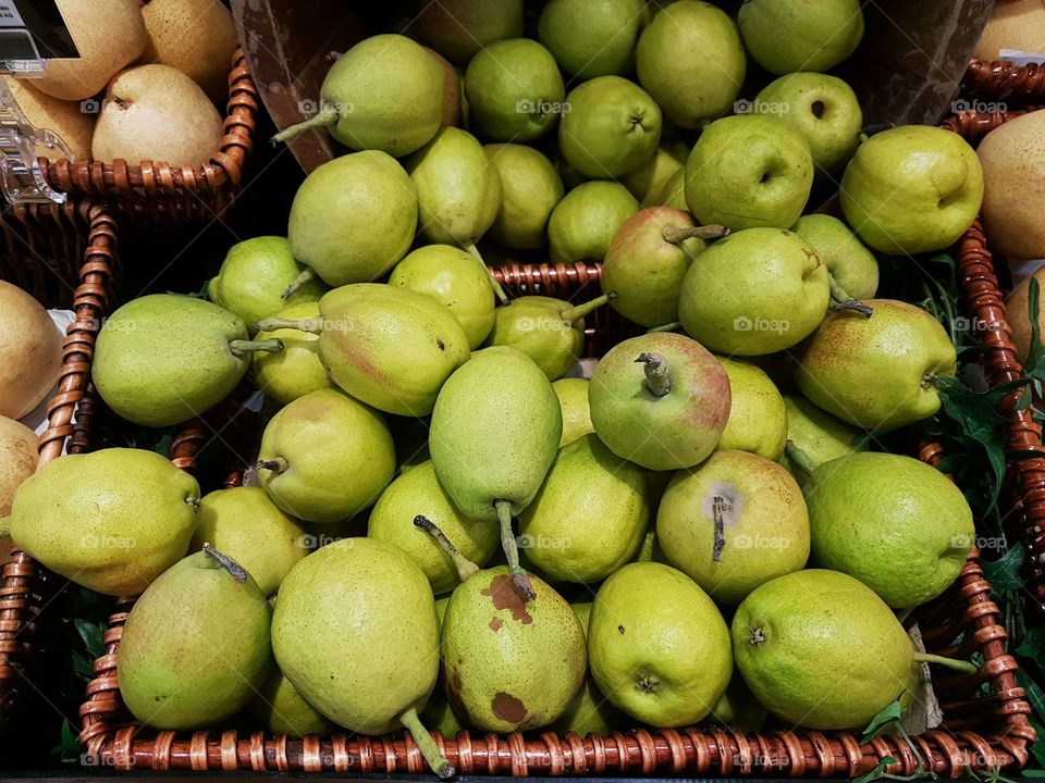 Sweet green pears displayed in basket