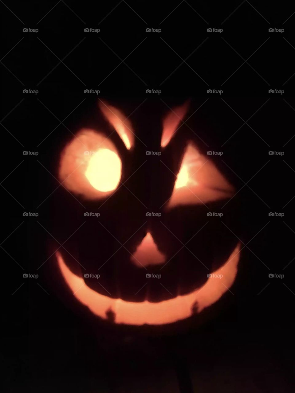 Jack-o’-lantern. Glowing Face. Orange Light.