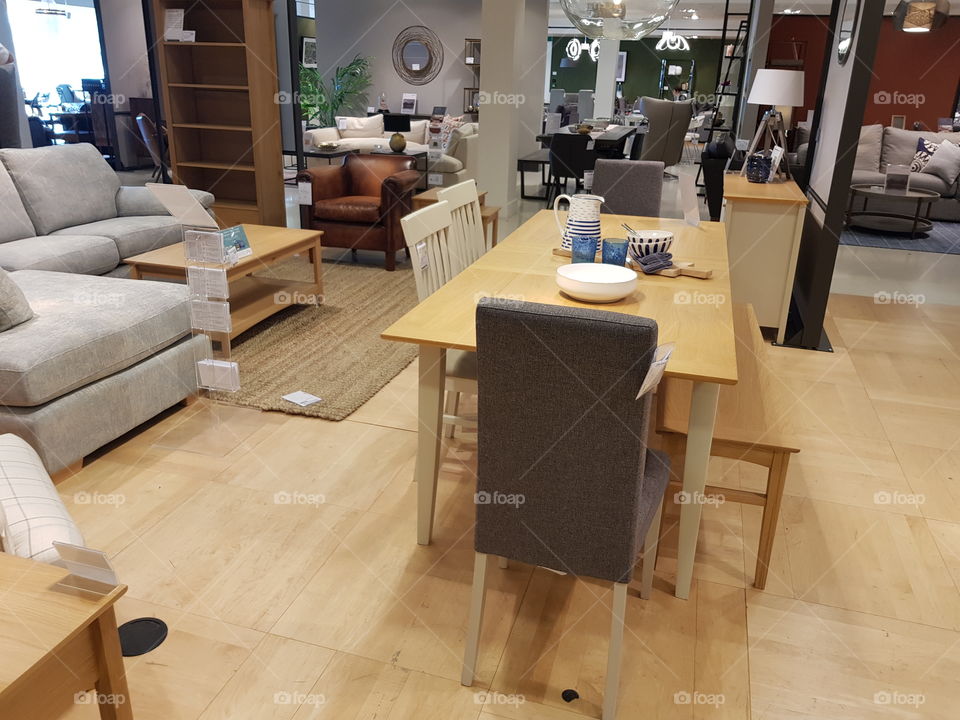 Wooden dining table with chairs and benches at Peter Jones Sloane square Chelsea King's road London