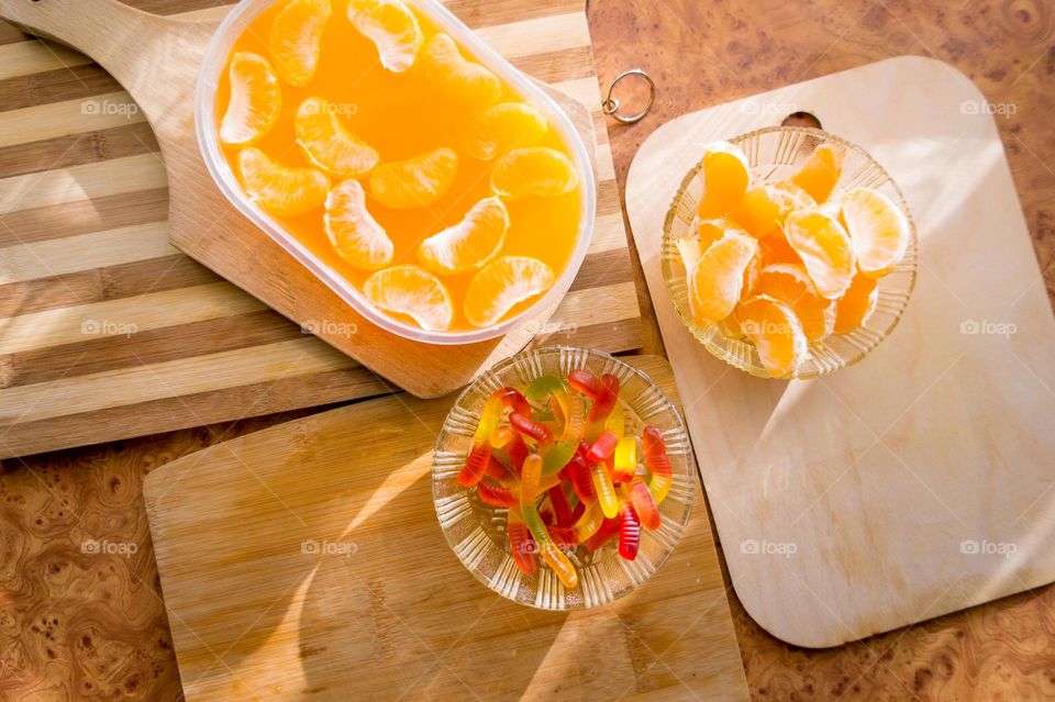 Delicious orange jelly with tangerine slices in a container and jelly worms.