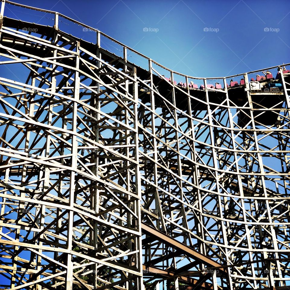 A curving wooden roller coaster. 