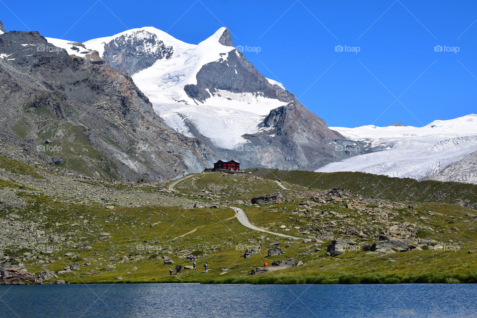 Swiss alps with a red house on a foothill