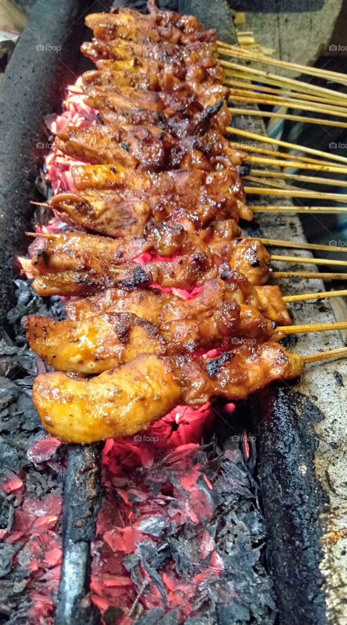 Indonesian food Sate. Grilled chicken on top of black carbon