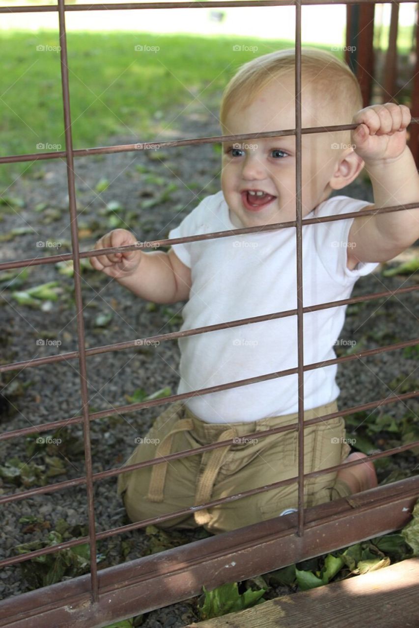 Happy boy near metallic gate