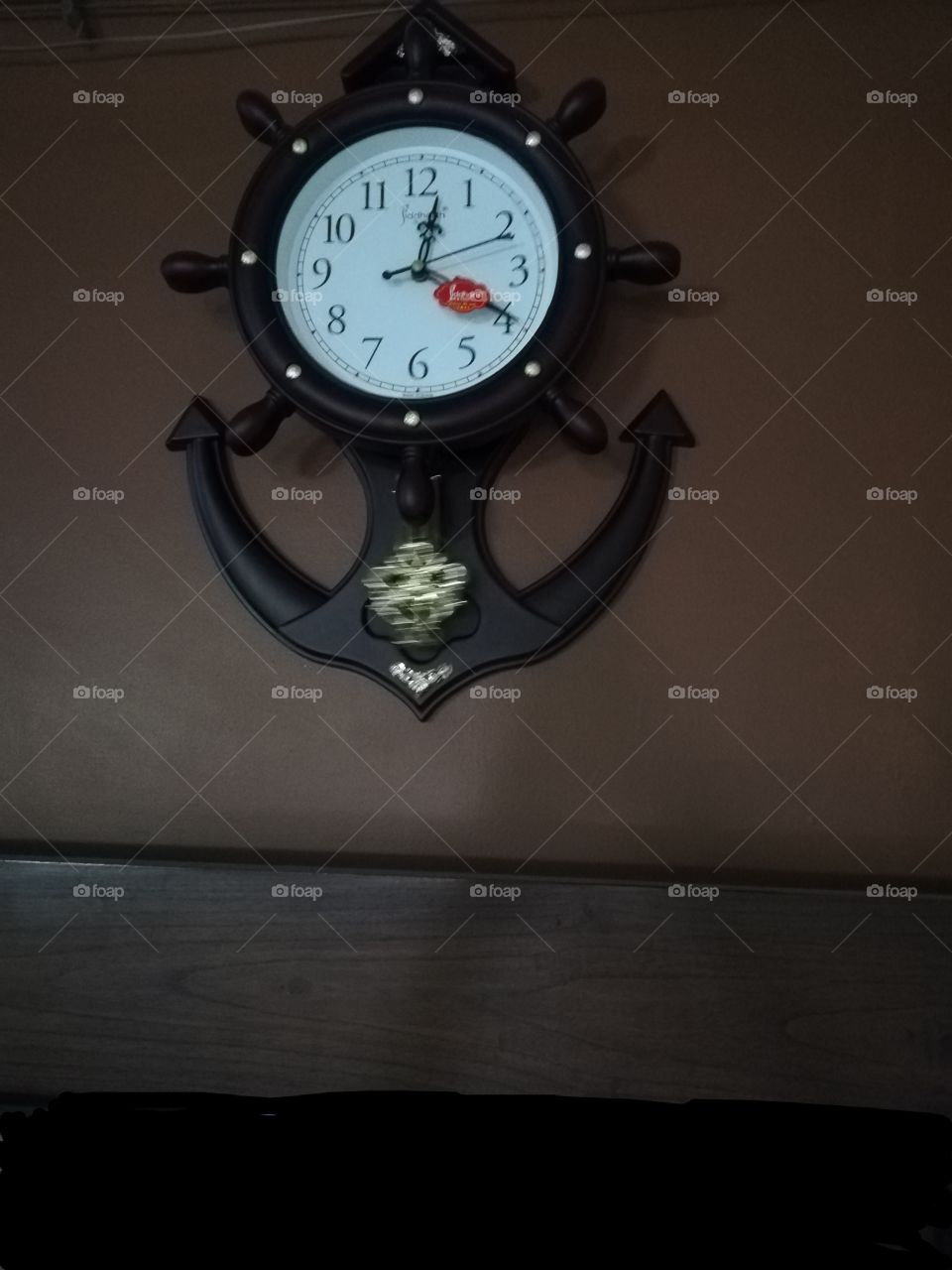 Wall clock with pendulum brown background