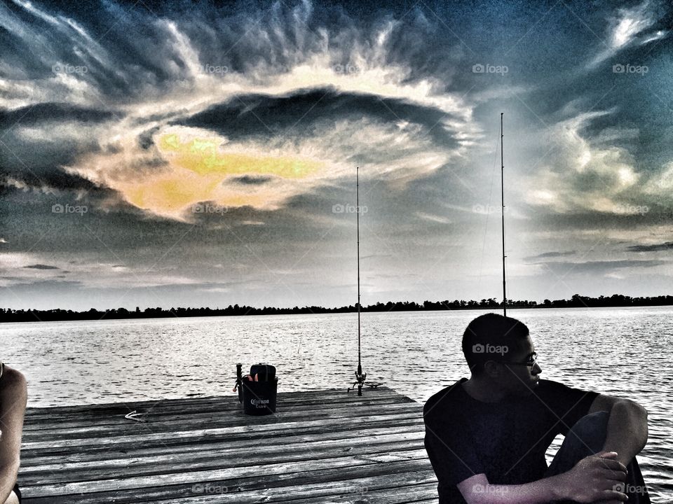 Chilling . Young man at the dock chilling at sunset