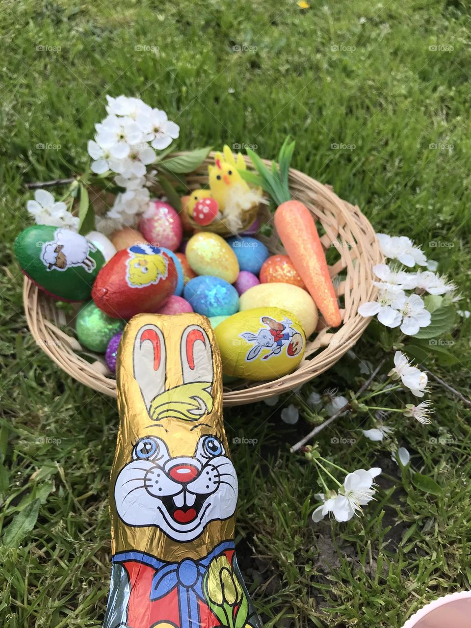 Basket of colorful easter eggs, sweet chocolate eggs, and the chocolate easter bunny