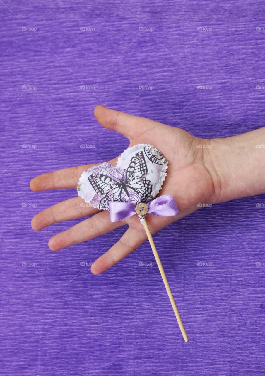 Textile heart with lavender seeds in a palm