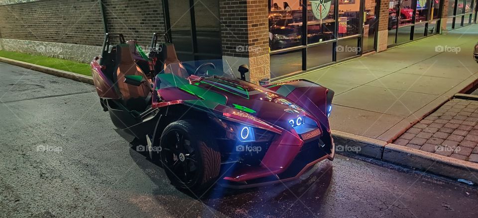 A blazing fast road race car glowing in the night.