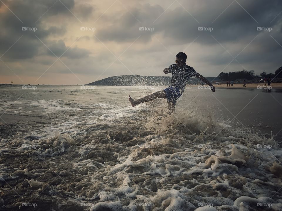 Man splashing wave with leg