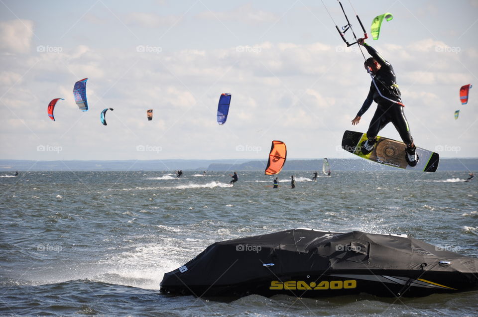 A kitesurfer jumping over an obstacle in a bay in Poland