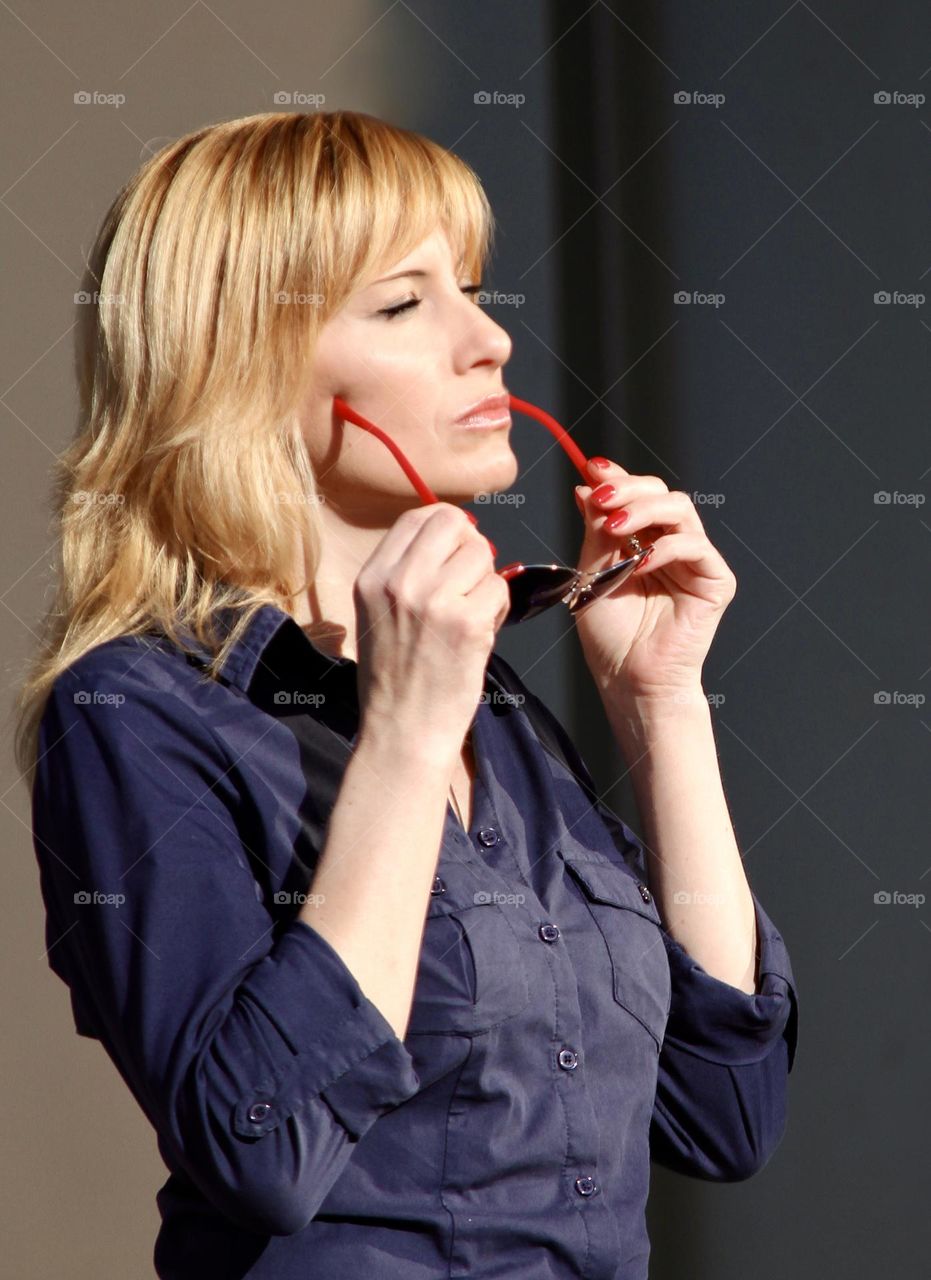 A woman puts on sunglasses