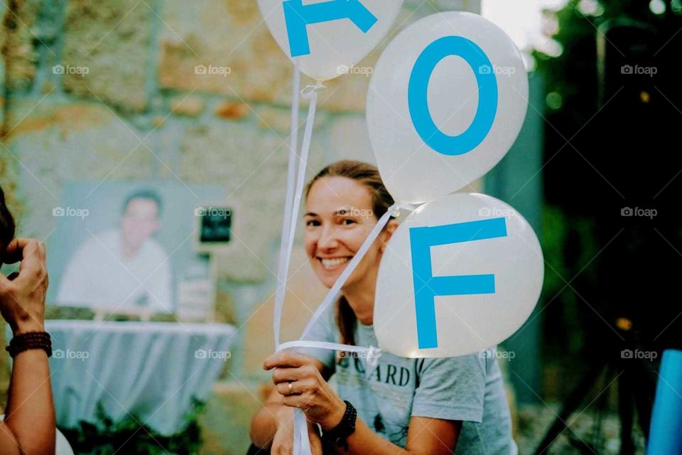 Woman holding balloons with FOAP letters