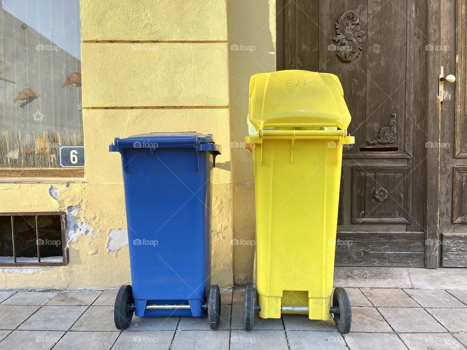 Blue and yellow trash bins