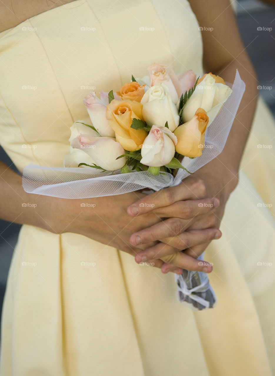 Yellow and white bouquet. Image of hands holding a yellow and white bouquet