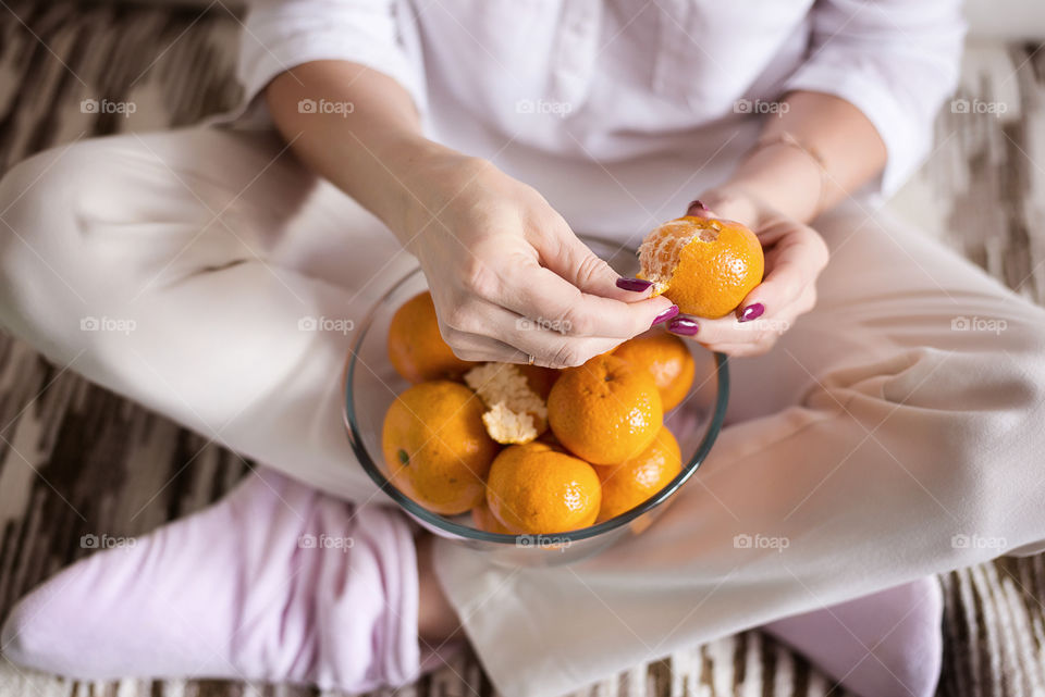 Woman cleaning a tangerines