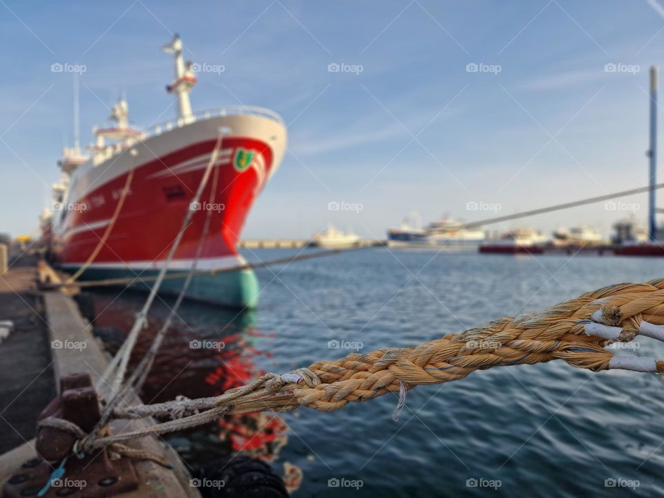 fishing boat moored with a rope in the port