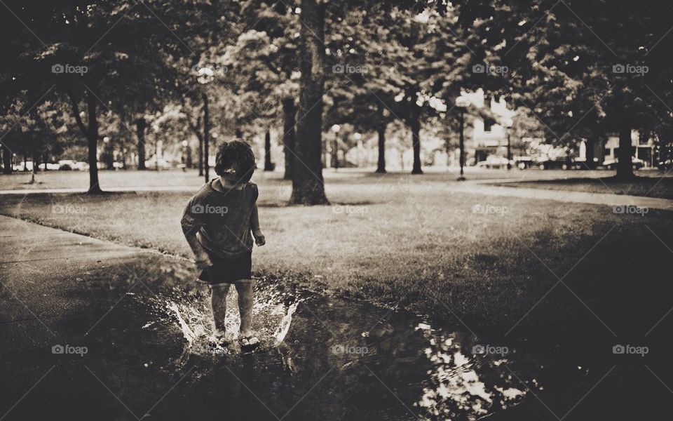 Child splashing in puddle